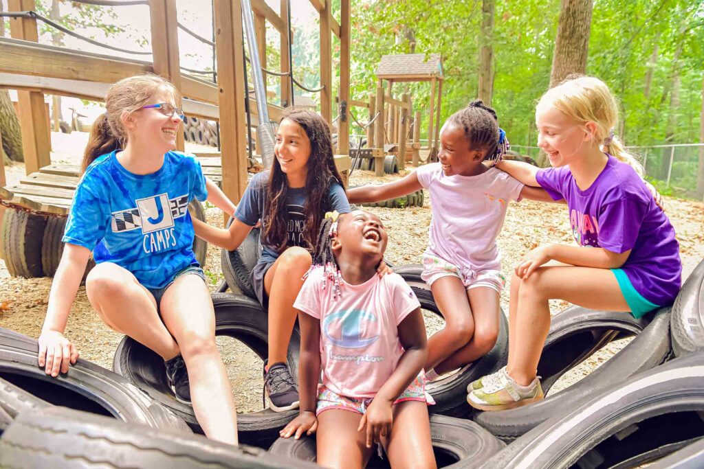 Five kids on tires in playground.