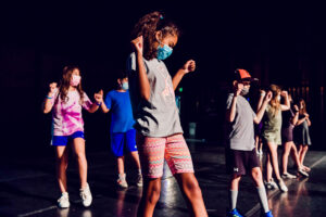 A group of campers performing on stage.