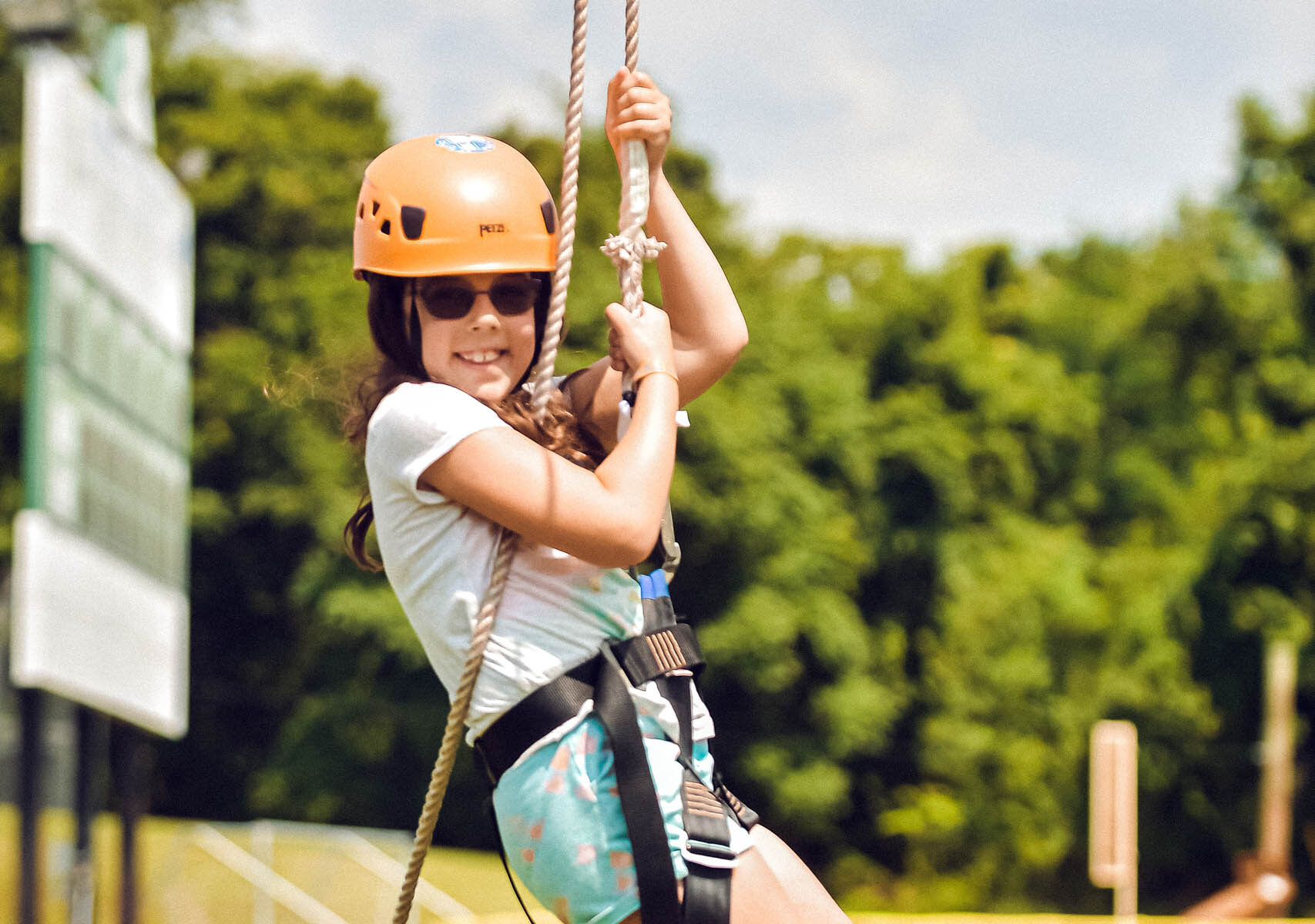 A camper riding a zipline.