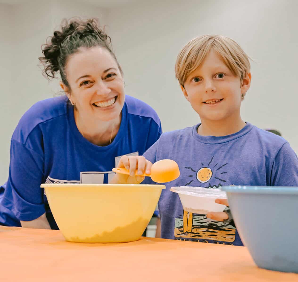 Camp counselor and camper preparing meal
